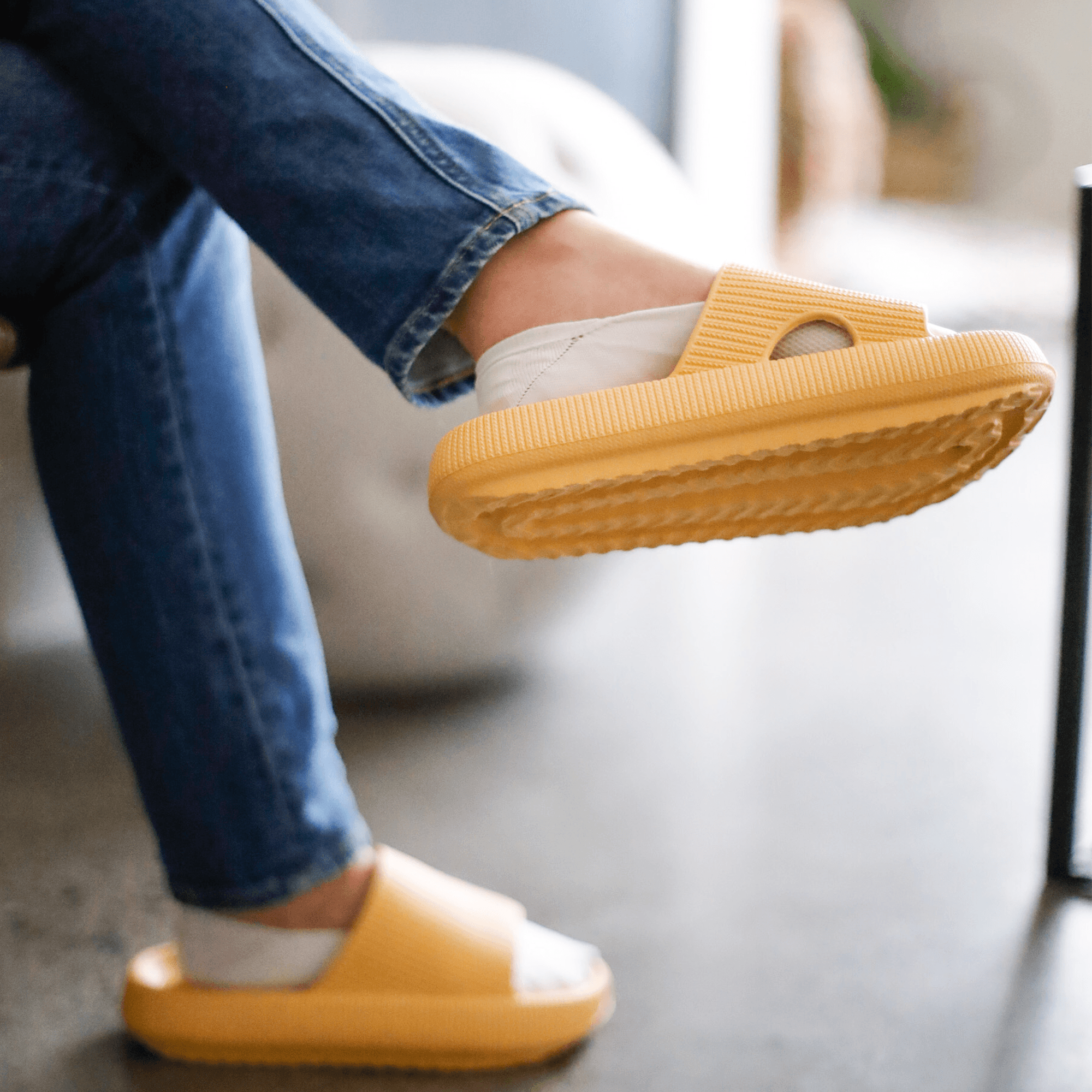 Sittende dame med gule Soft Slippers på føttene